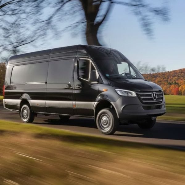 Black Mercedes Sprinter van driving on highway.