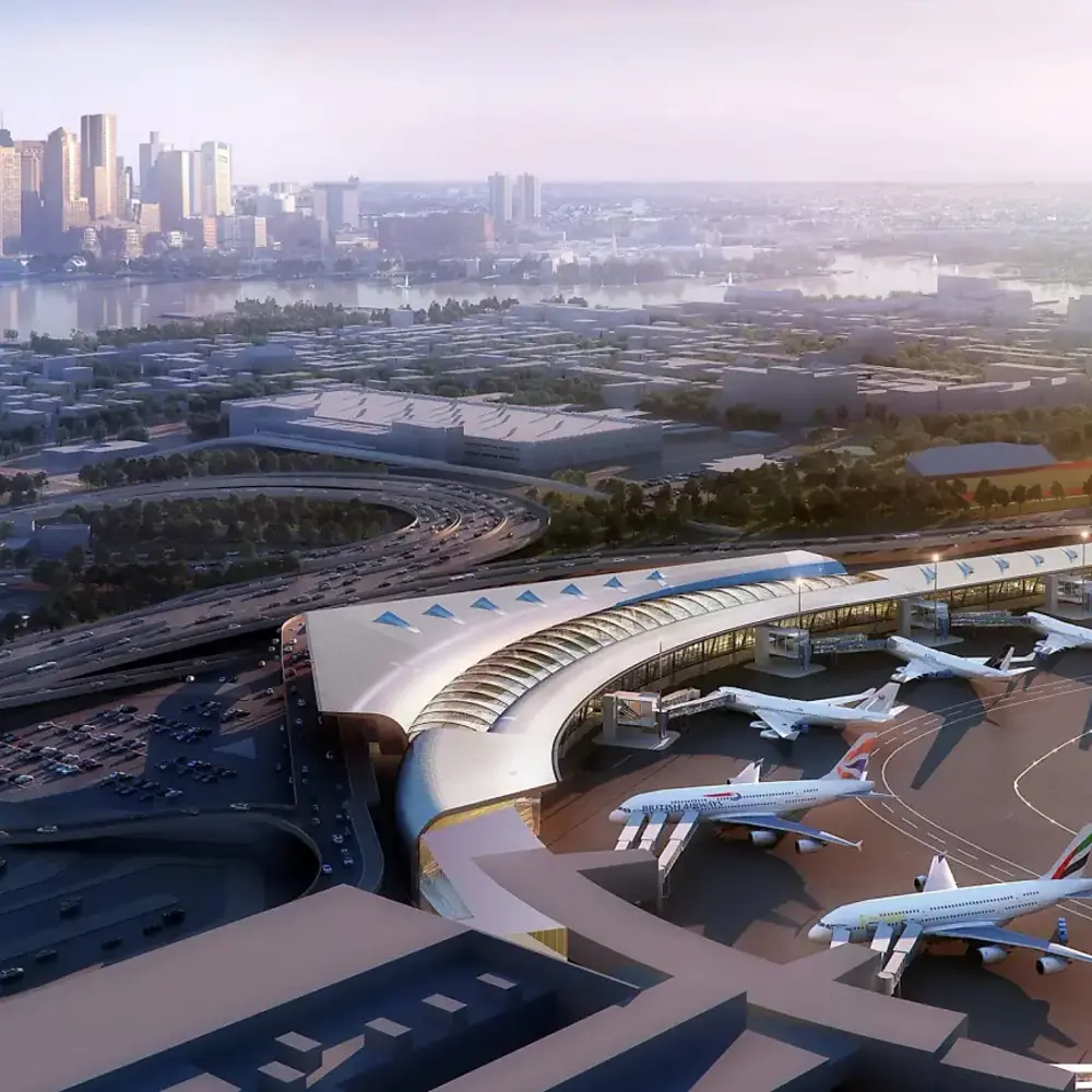 Logan Airport A modern, curved airport terminal with several large airplanes parked at gates, featuring a highway interchange and the Boston skyline in the background.